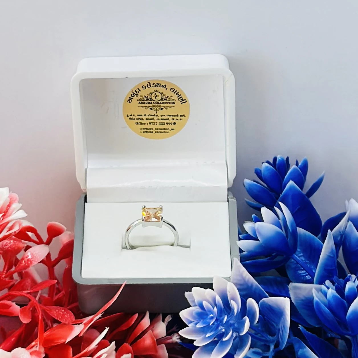 silver-toned solitaire ring with a square-cut yellow gemstone, possibly a citrine or cubic zirconia.
