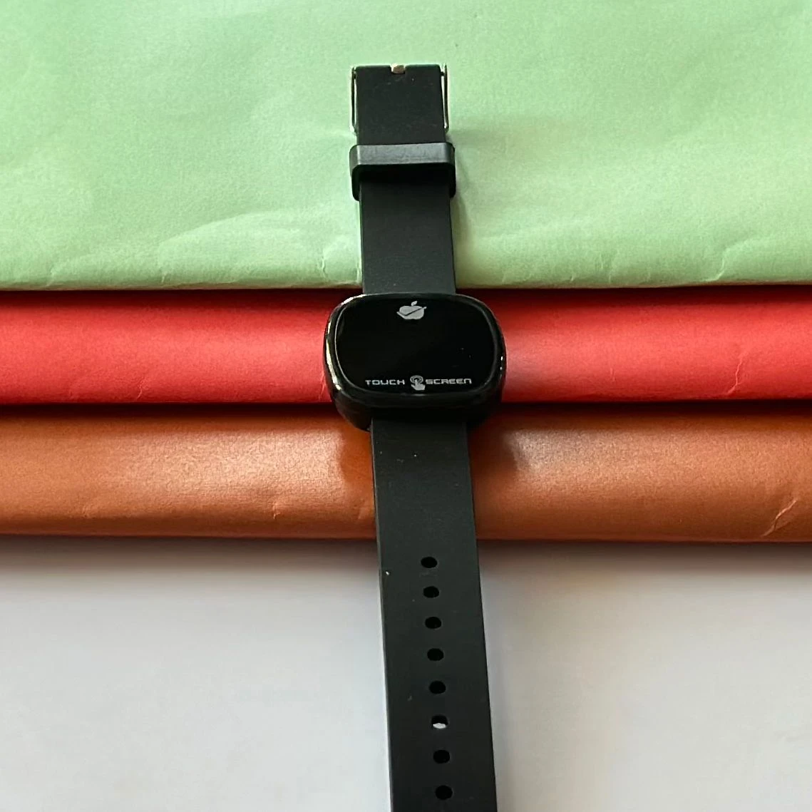 pink silicone strap and a gold-toned square dial.