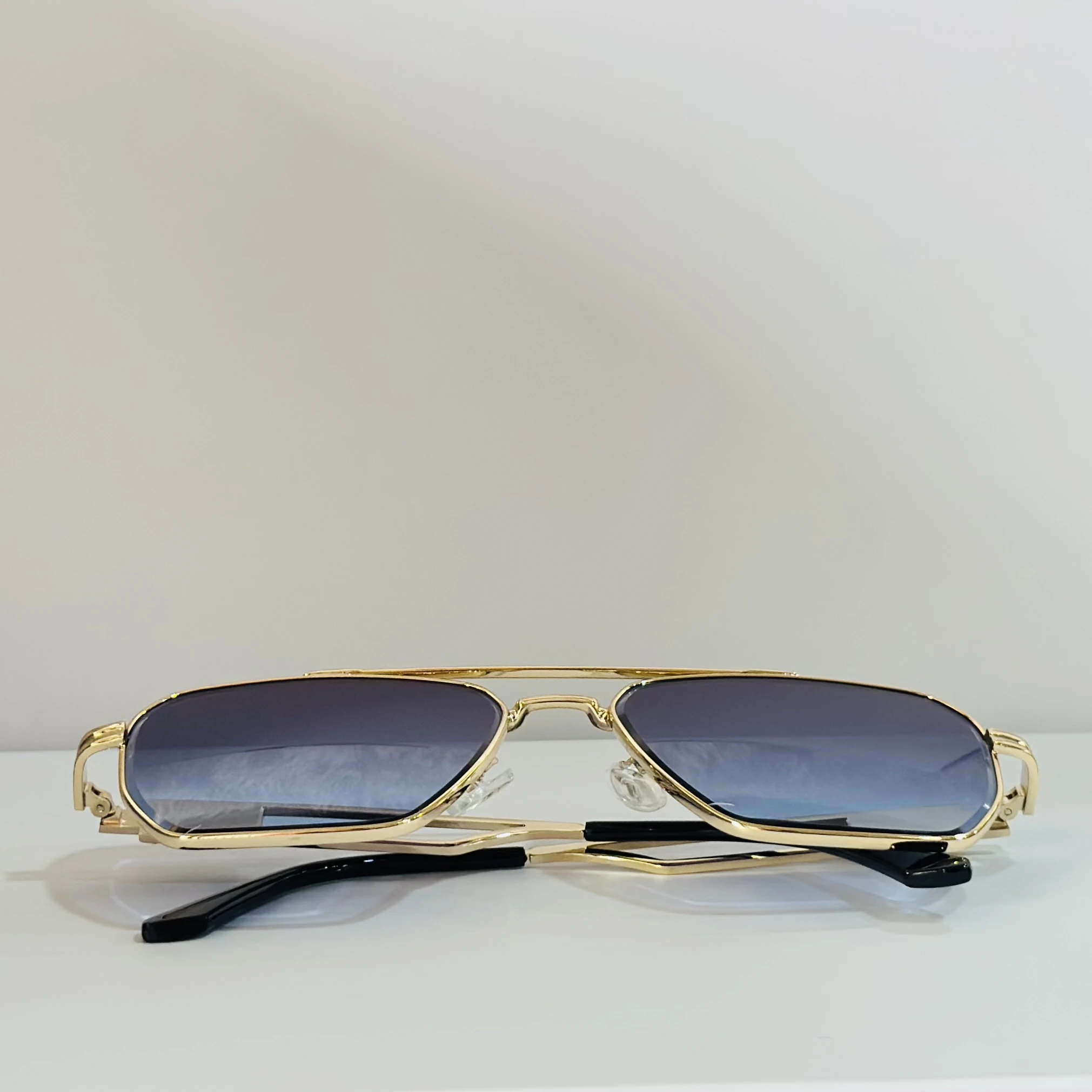 pair of gold-toned aviator sunglasses with gradient lenses.