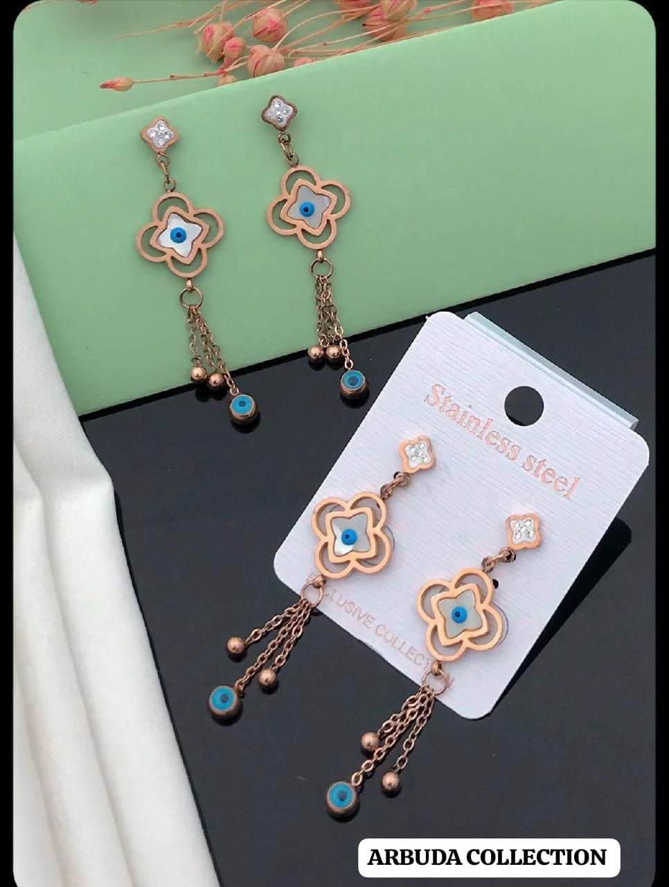 Rose gold-toned, stainless steel flower and evil eye drop earrings.