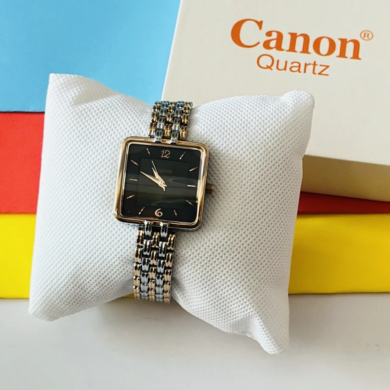 women's analog wristwatch with a square black dial and a dual-tone metallic link bracelet, resting on a white display cushion.