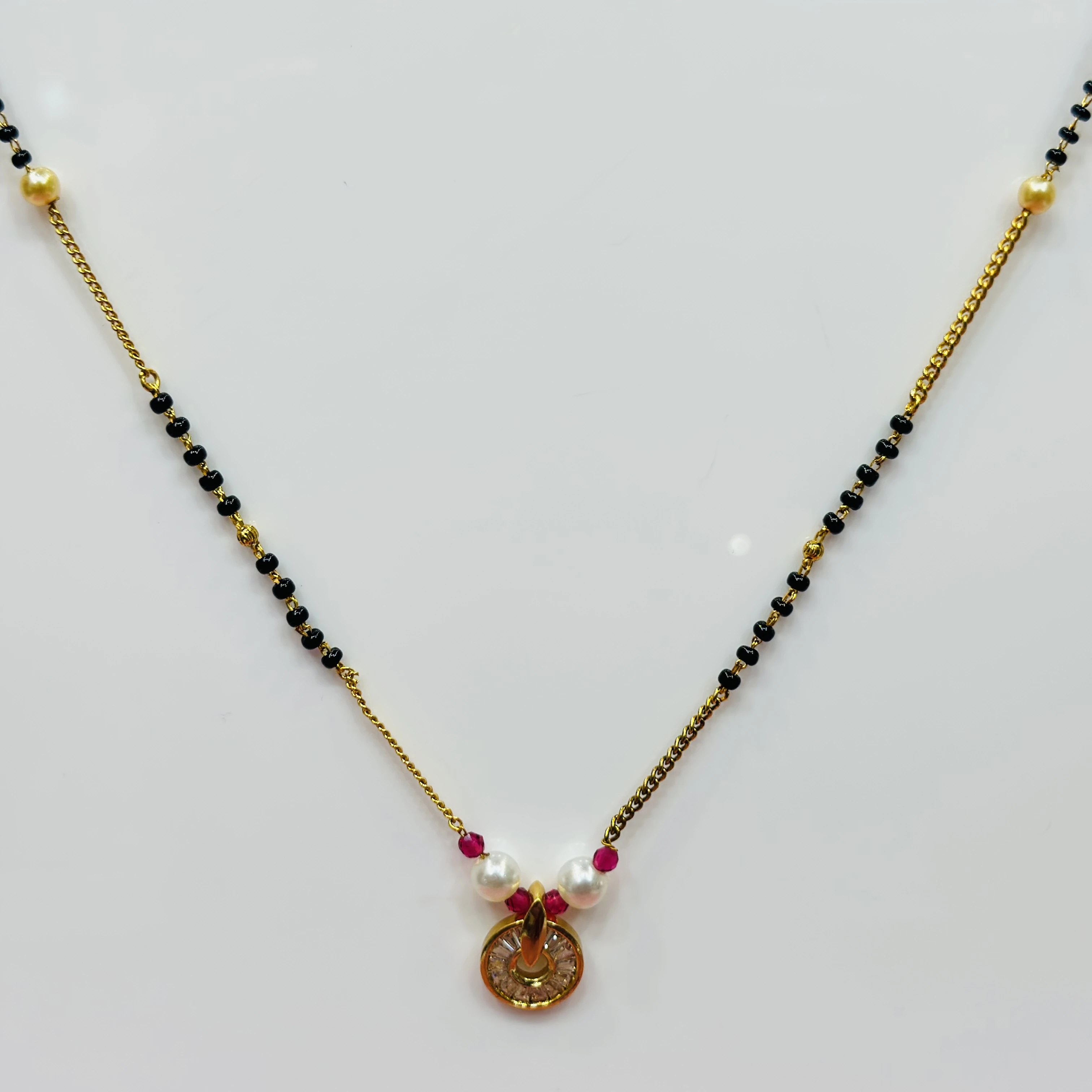 gold-plated cubic zirconia and pearl mangalsutra with red accents.