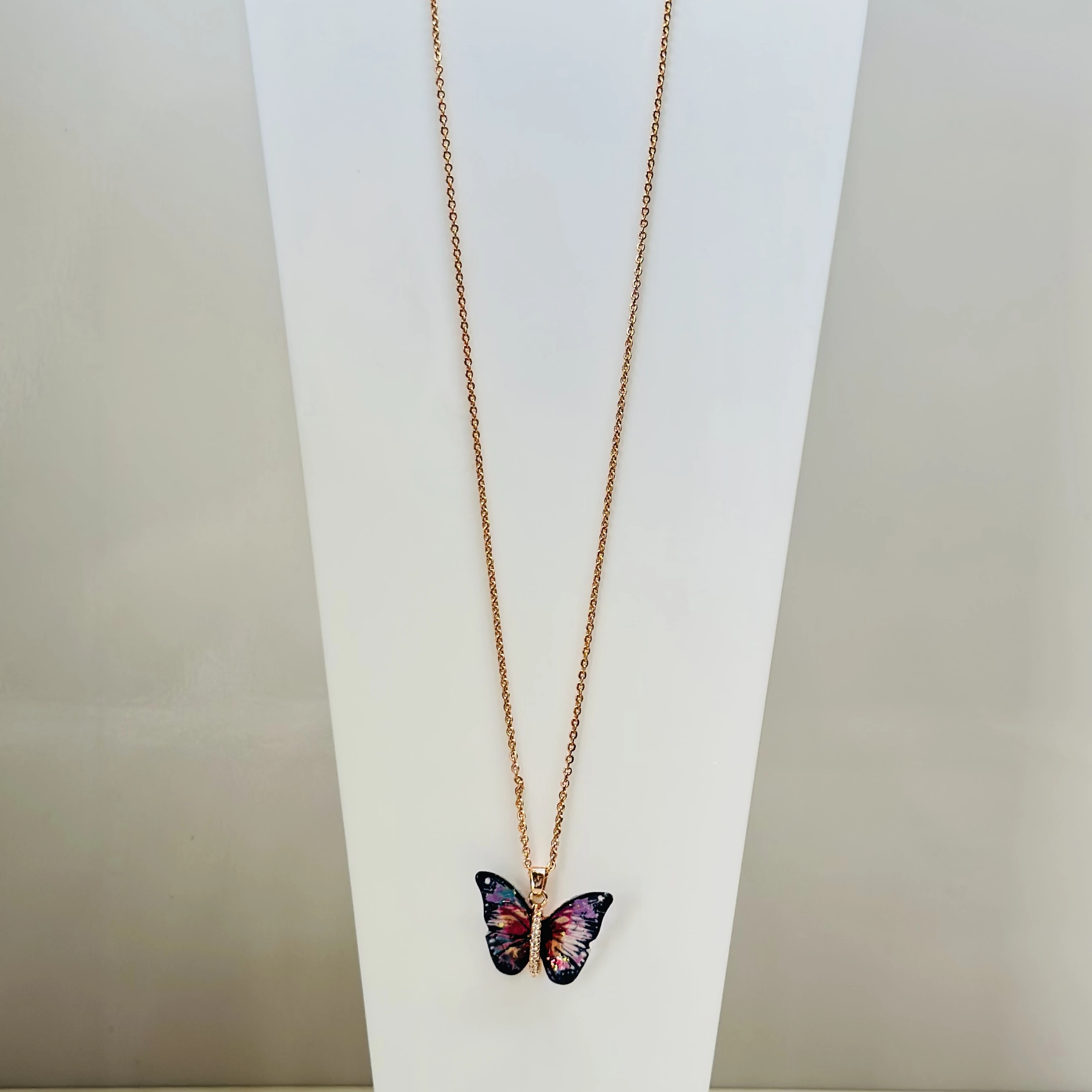 Rose gold-toned with a colorful butterfly pendant featuring a rhinestone accent