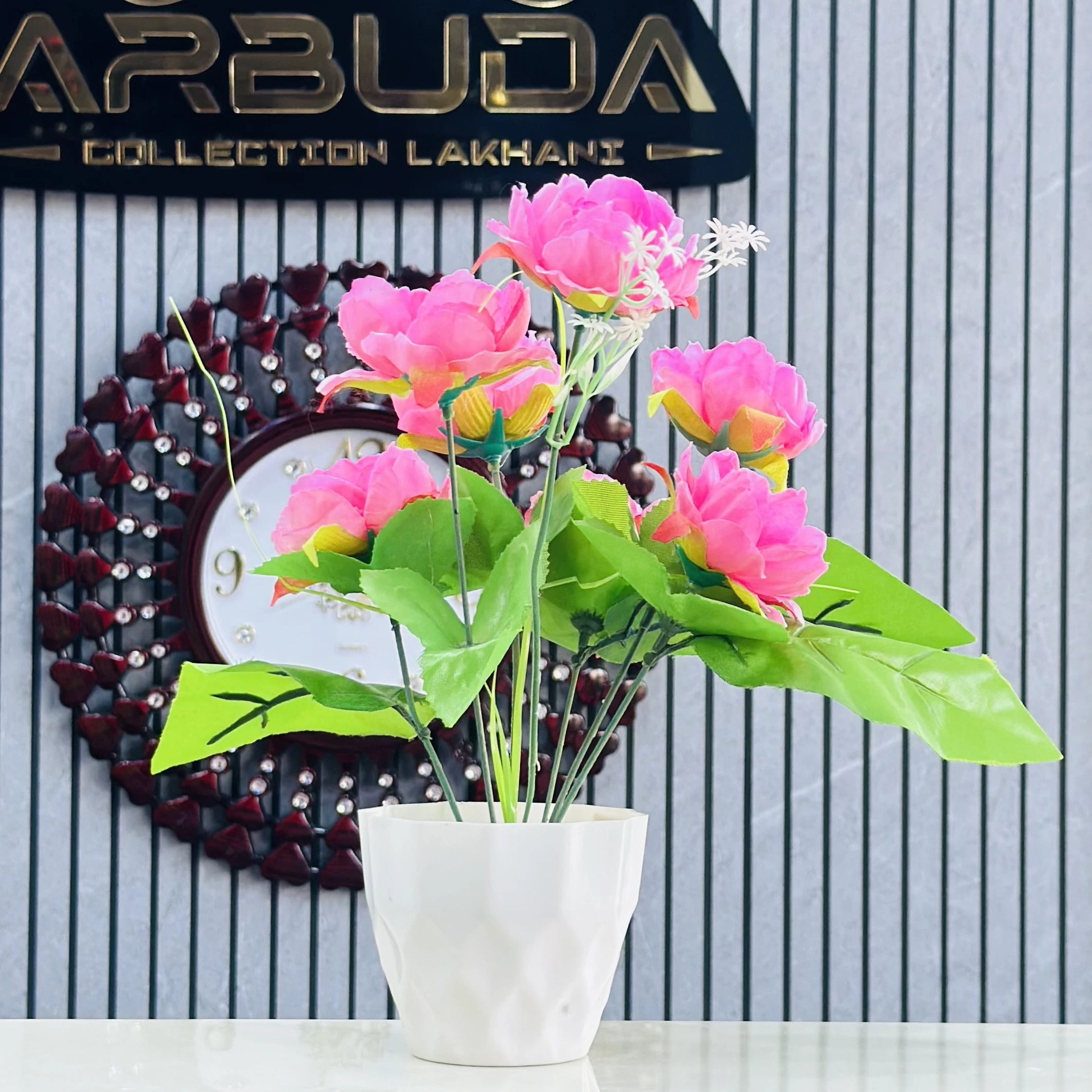 Pink  lotus flower arrangement in a white pot.