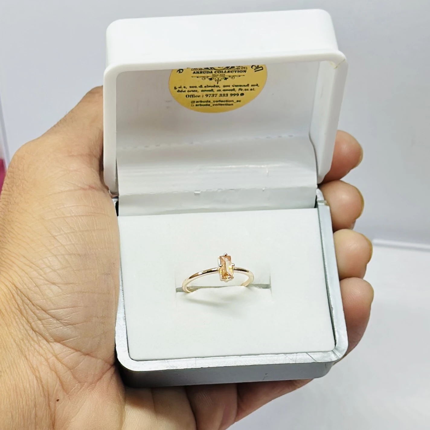 An emerald-cut imperial topaz or citrine solitaire ring in 14k gold.