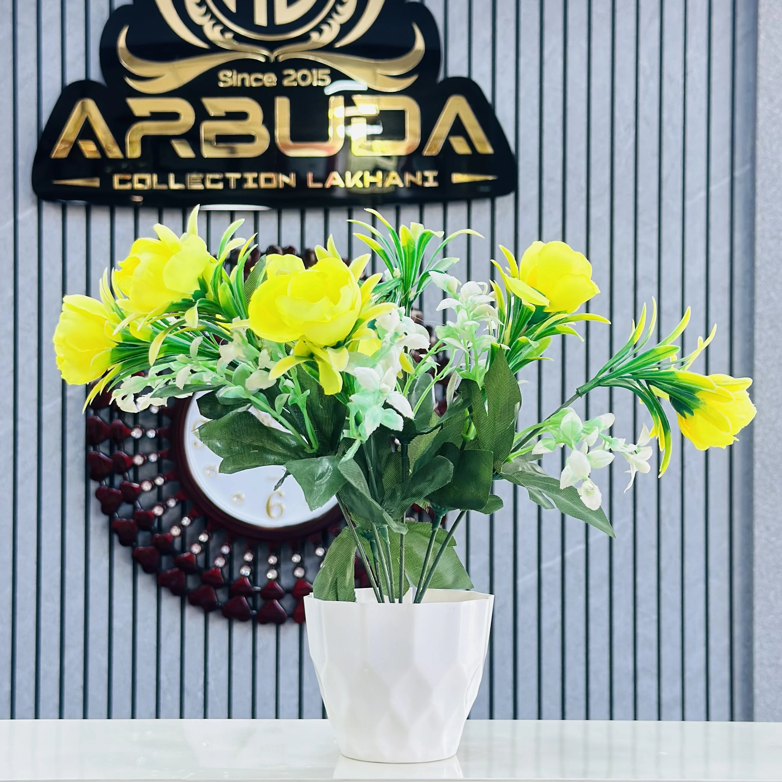 Yellow flower arrangement in a white ceramic pot.