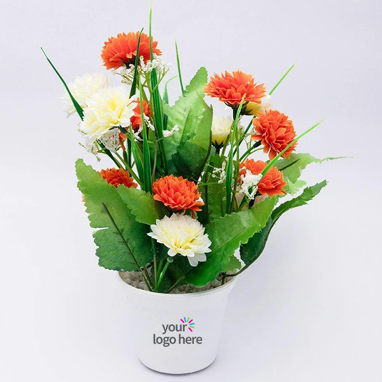 An artificial carnation flower arrangement in a white pot.