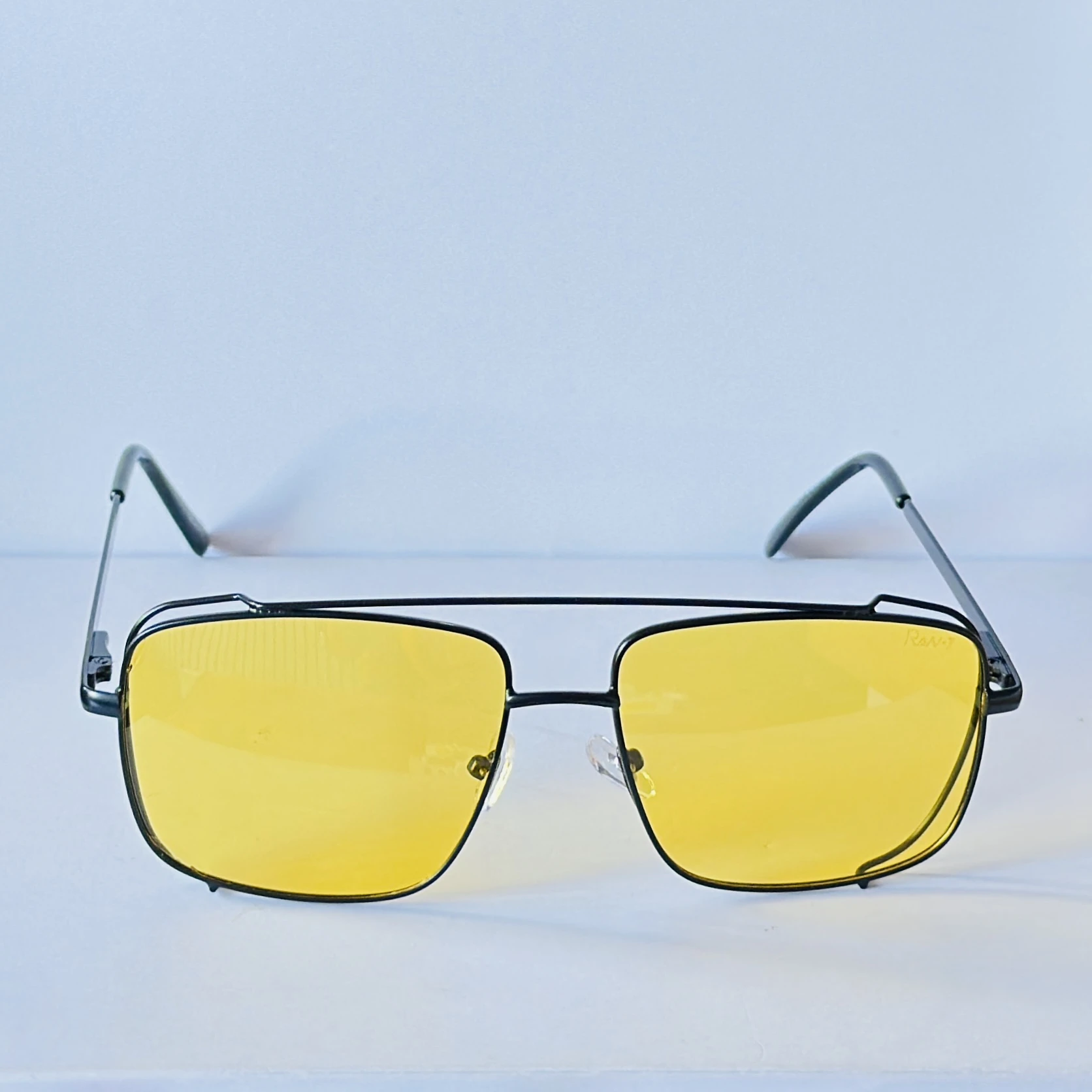 pair of unisex yellow lens square sunglasses featuring a metal frame.