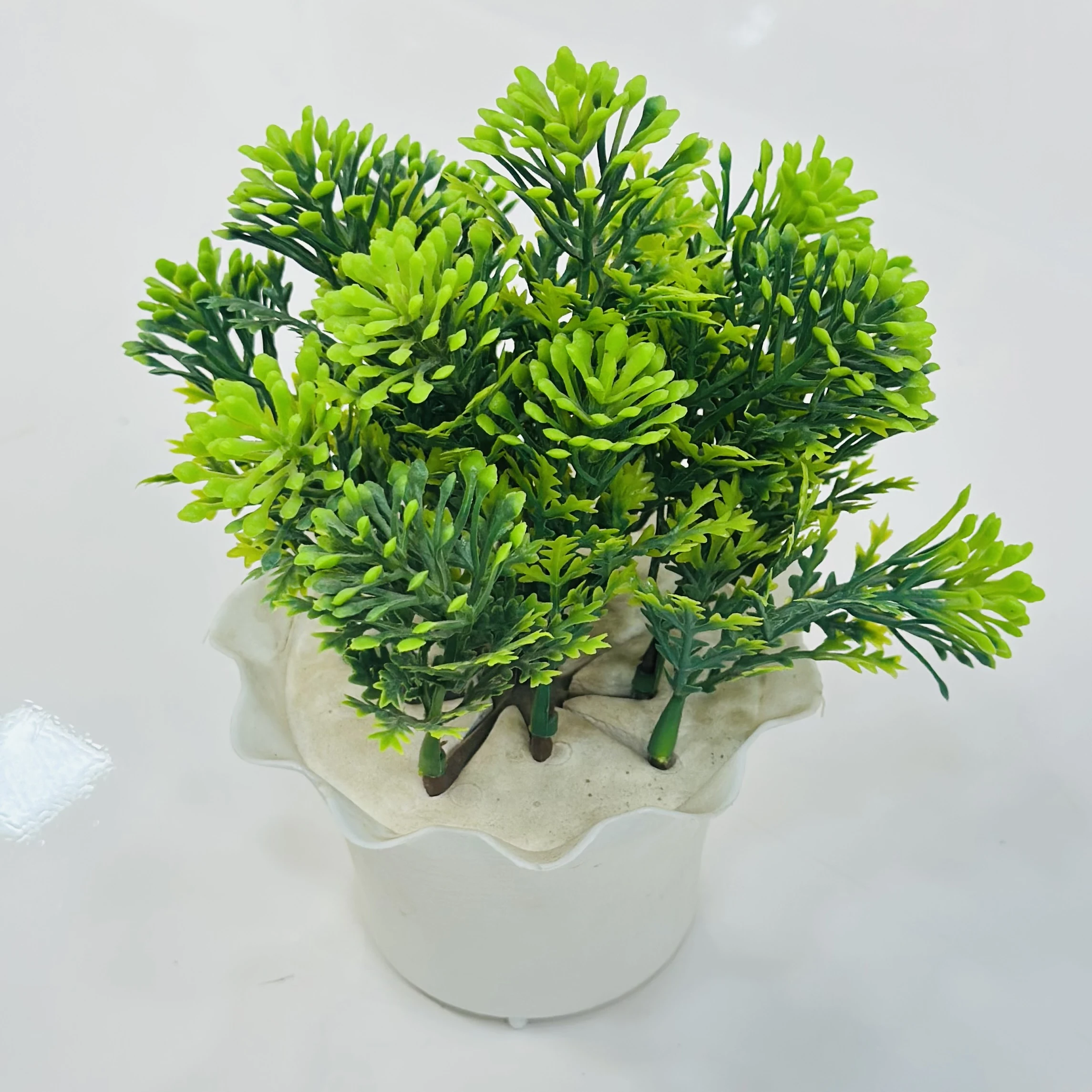 small, artificial potted plant, likely made from plastic materials.