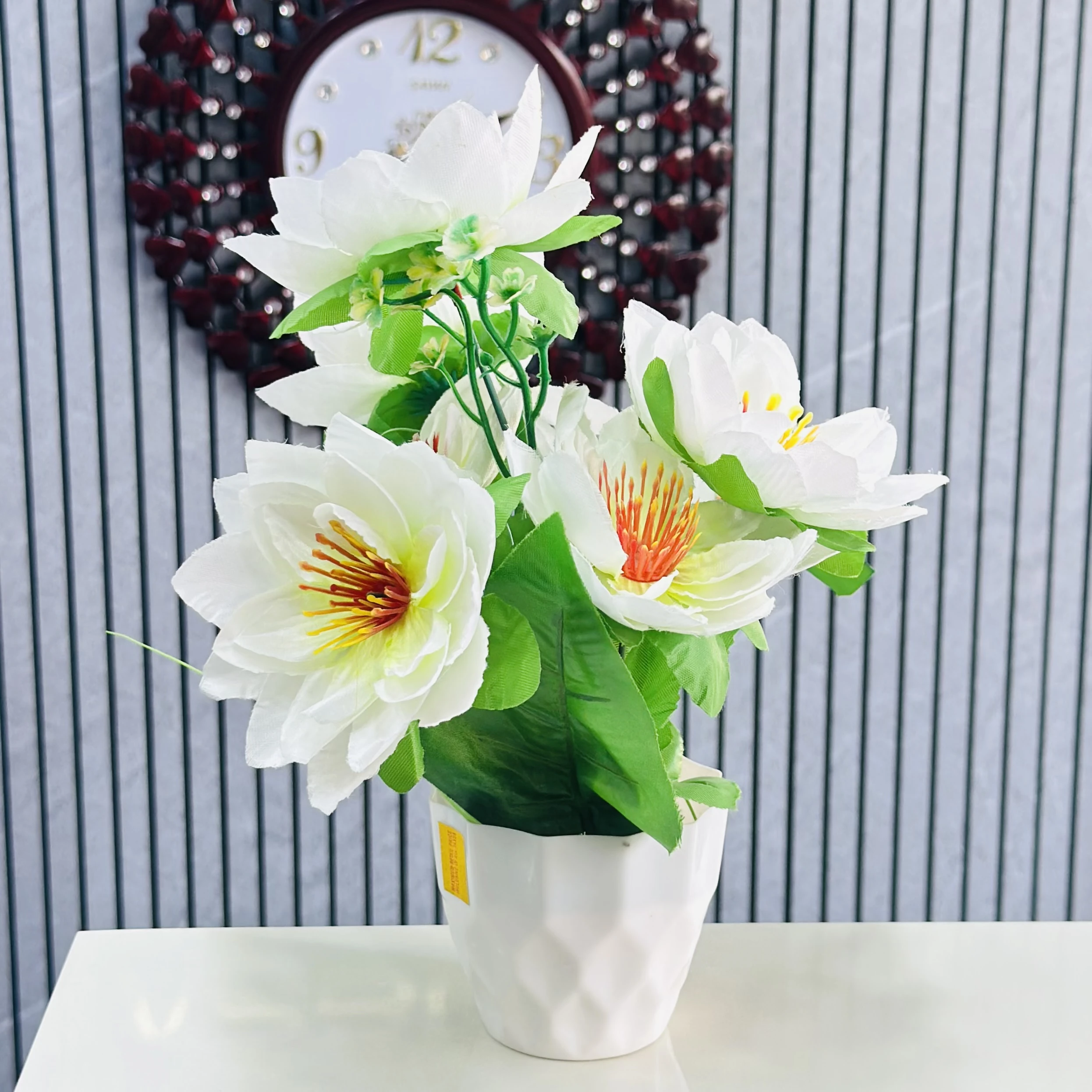 Flower arrangement in a white ceramic pot.