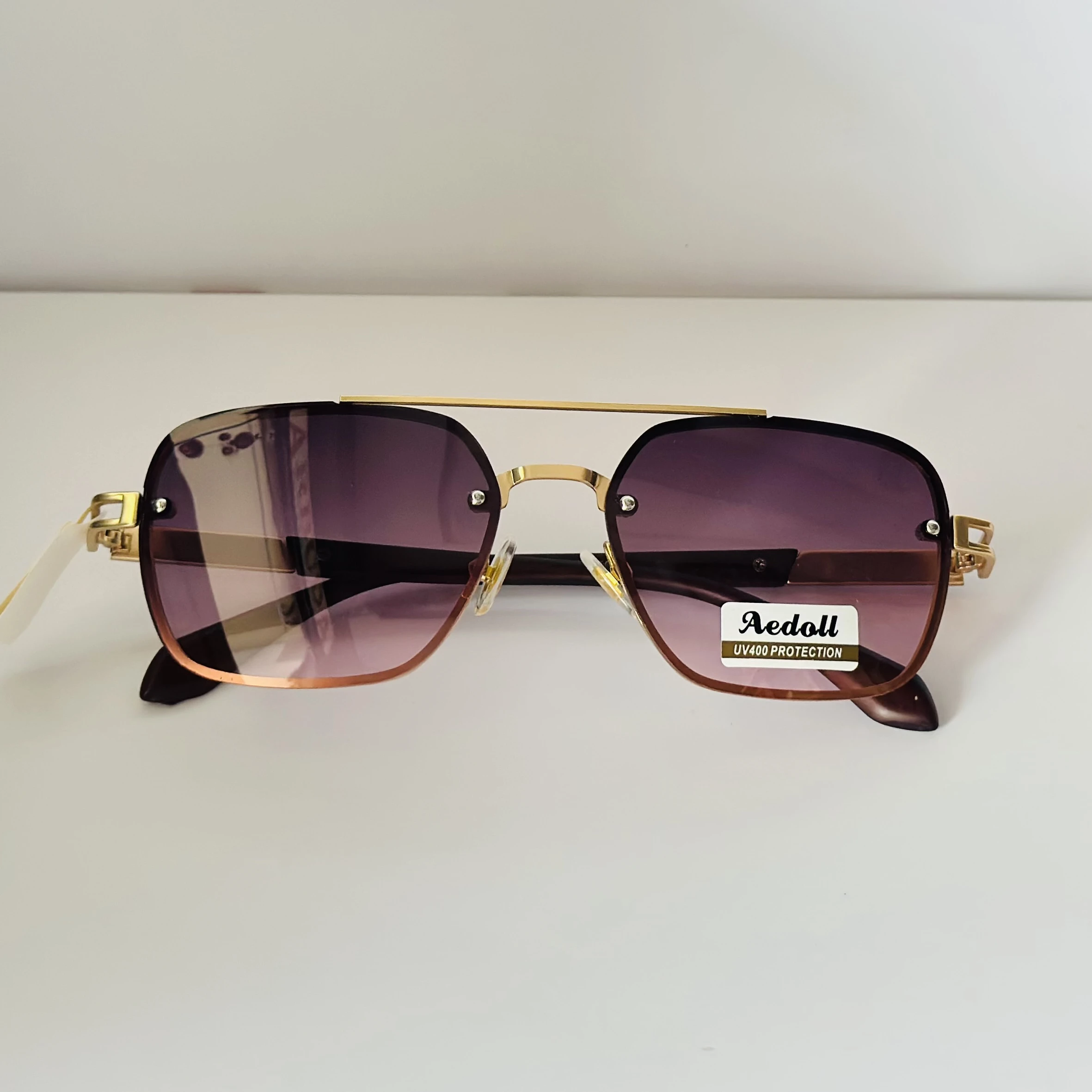pair of Aedoll Goggle sunglasses with a gold metal frame and pink gradient lenses.