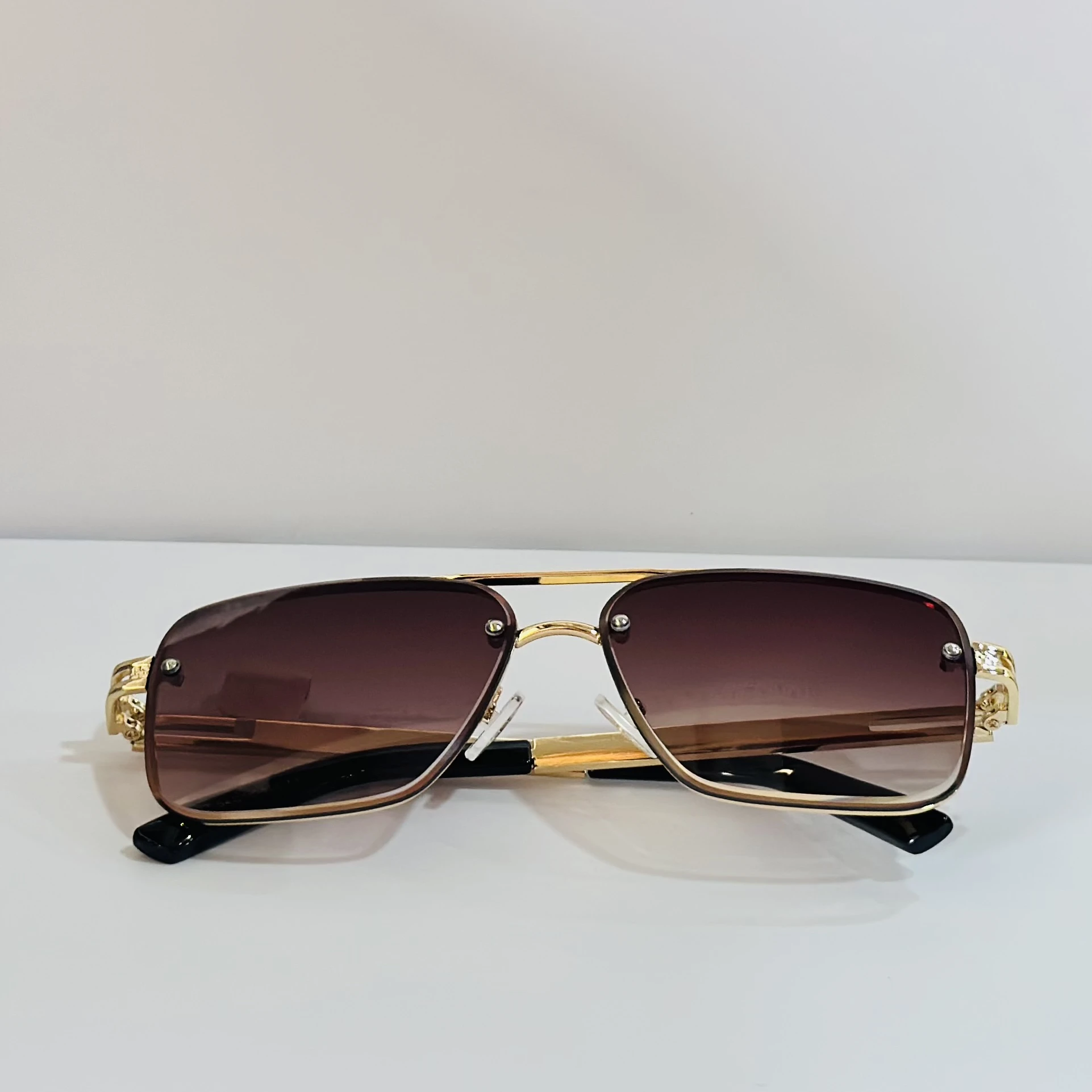 pair of Maybach-style sunglasses with gold-toned frames and brown gradient lenses.