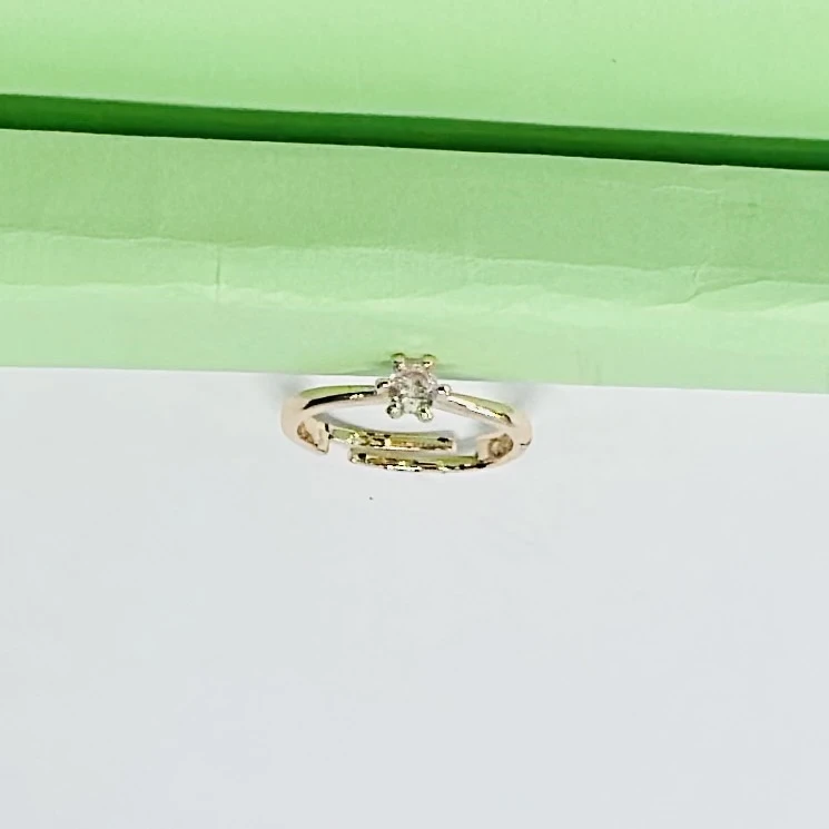 Gold solitaire engagement ring with a single round clear gemstone.