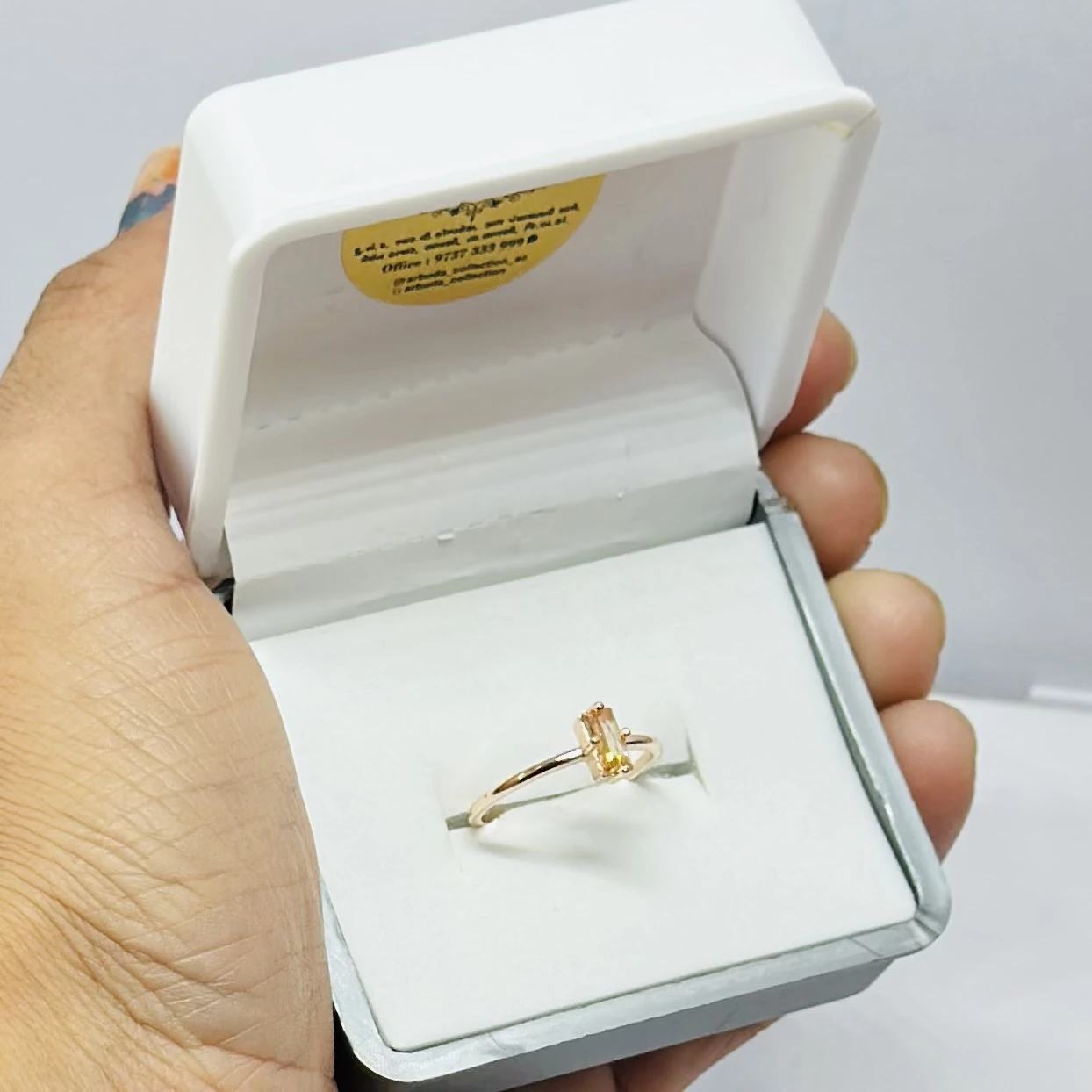 An emerald-cut imperial topaz or citrine solitaire ring in 14k gold.