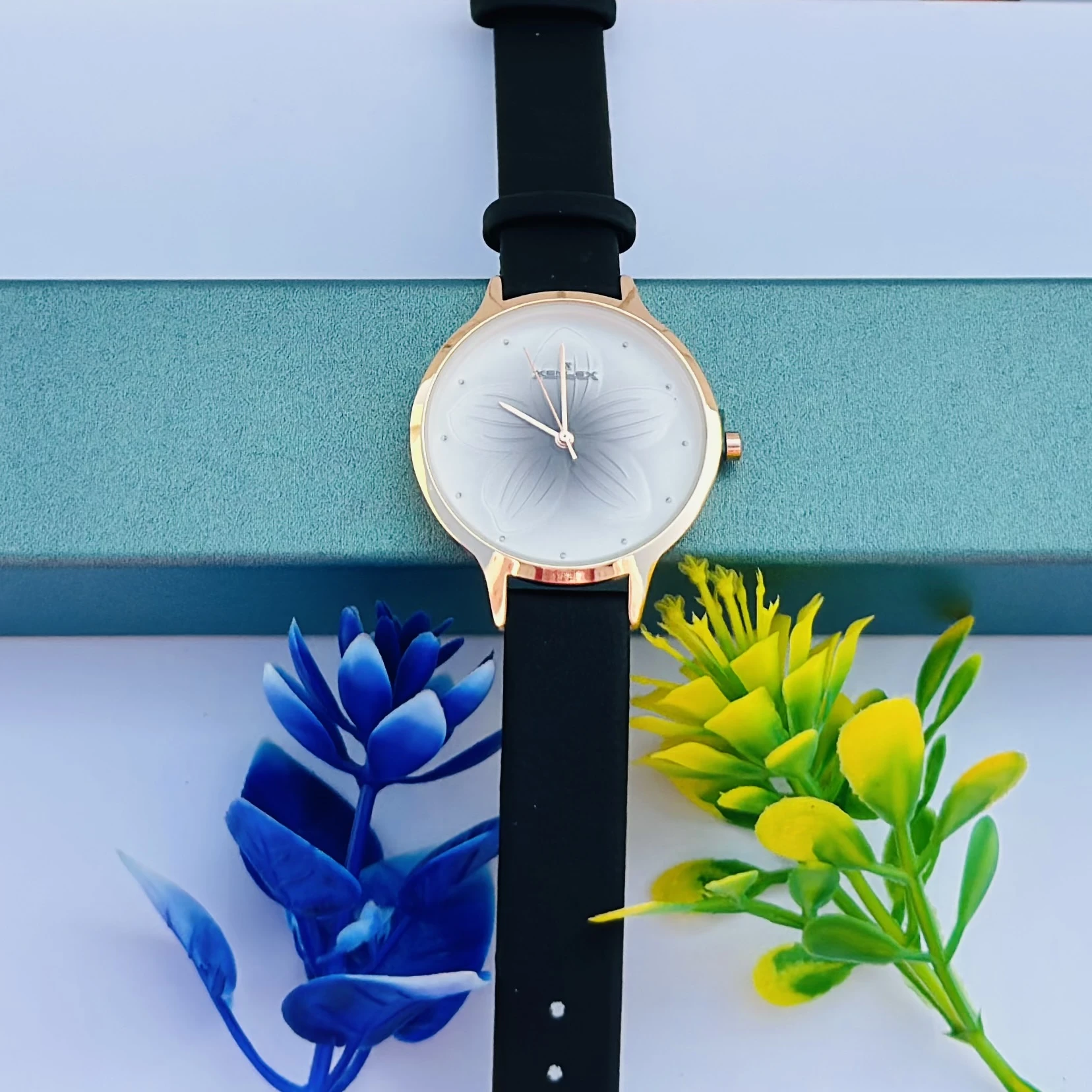 Analog with Pink Dial watch for women with a black plastic strap.