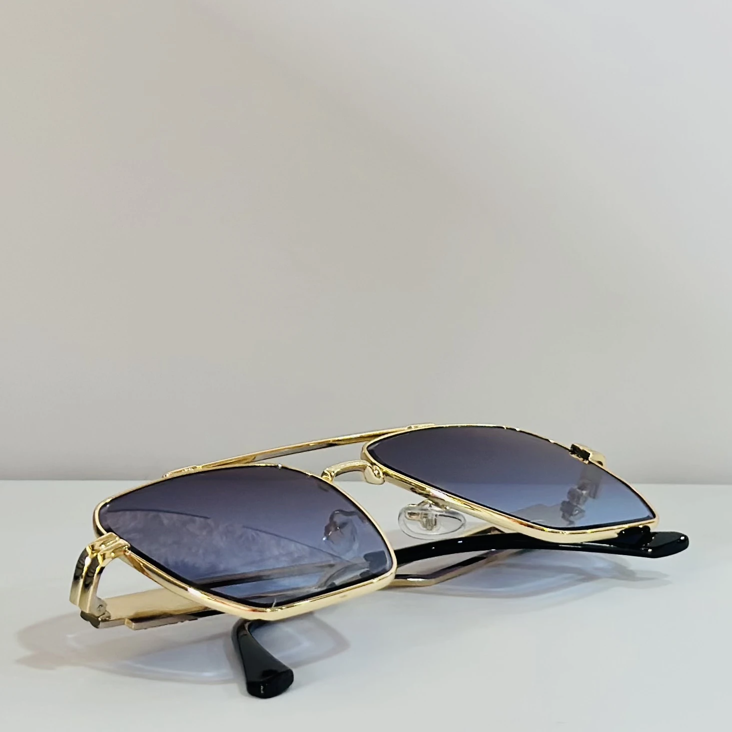 pair of gold-toned aviator sunglasses with gradient lenses.