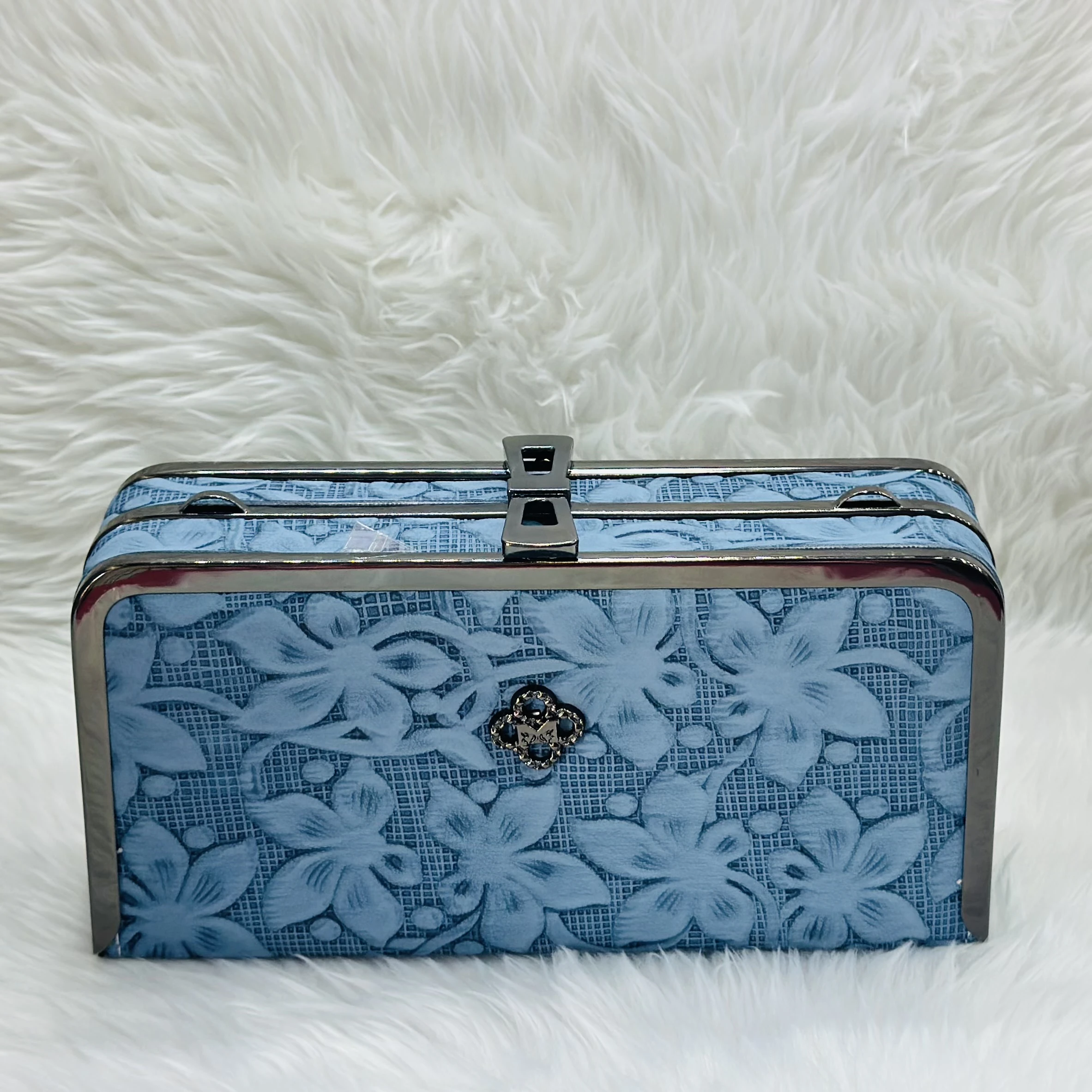 Light blue floral embossed clutch bag with a metal frame and clasp.