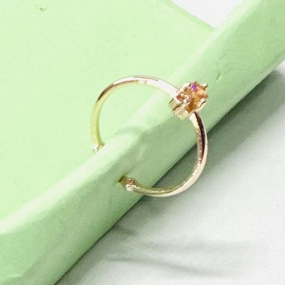 An emerald-cut imperial topaz or citrine solitaire ring in 14k gold.
