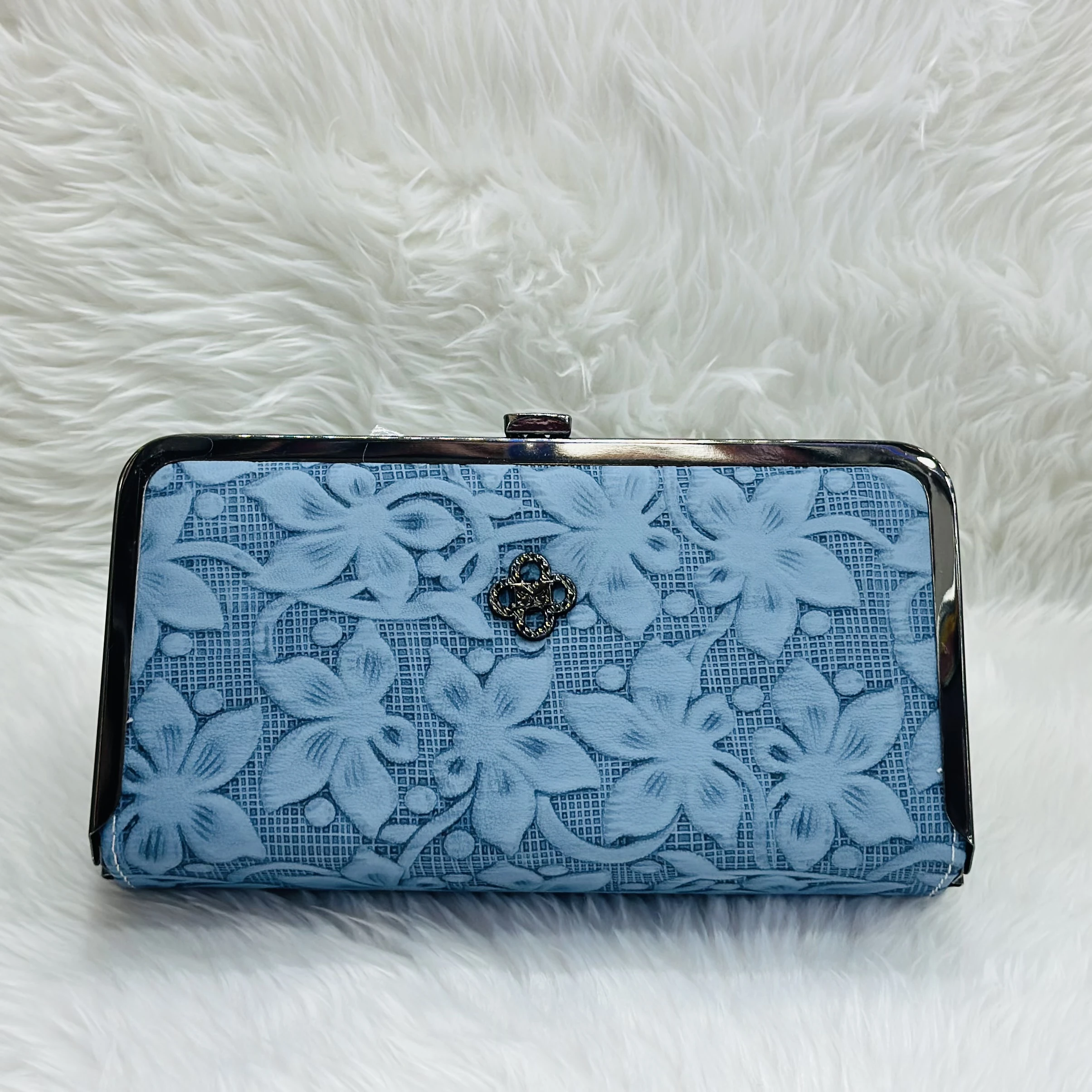 Light blue floral embossed clutch bag with a metal frame and clasp.