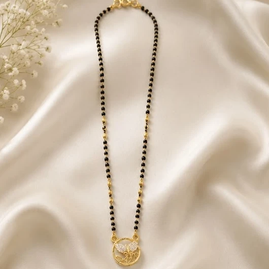mangalsutra features 18K gold plating with American diamond-studded details and a black beaded chain.