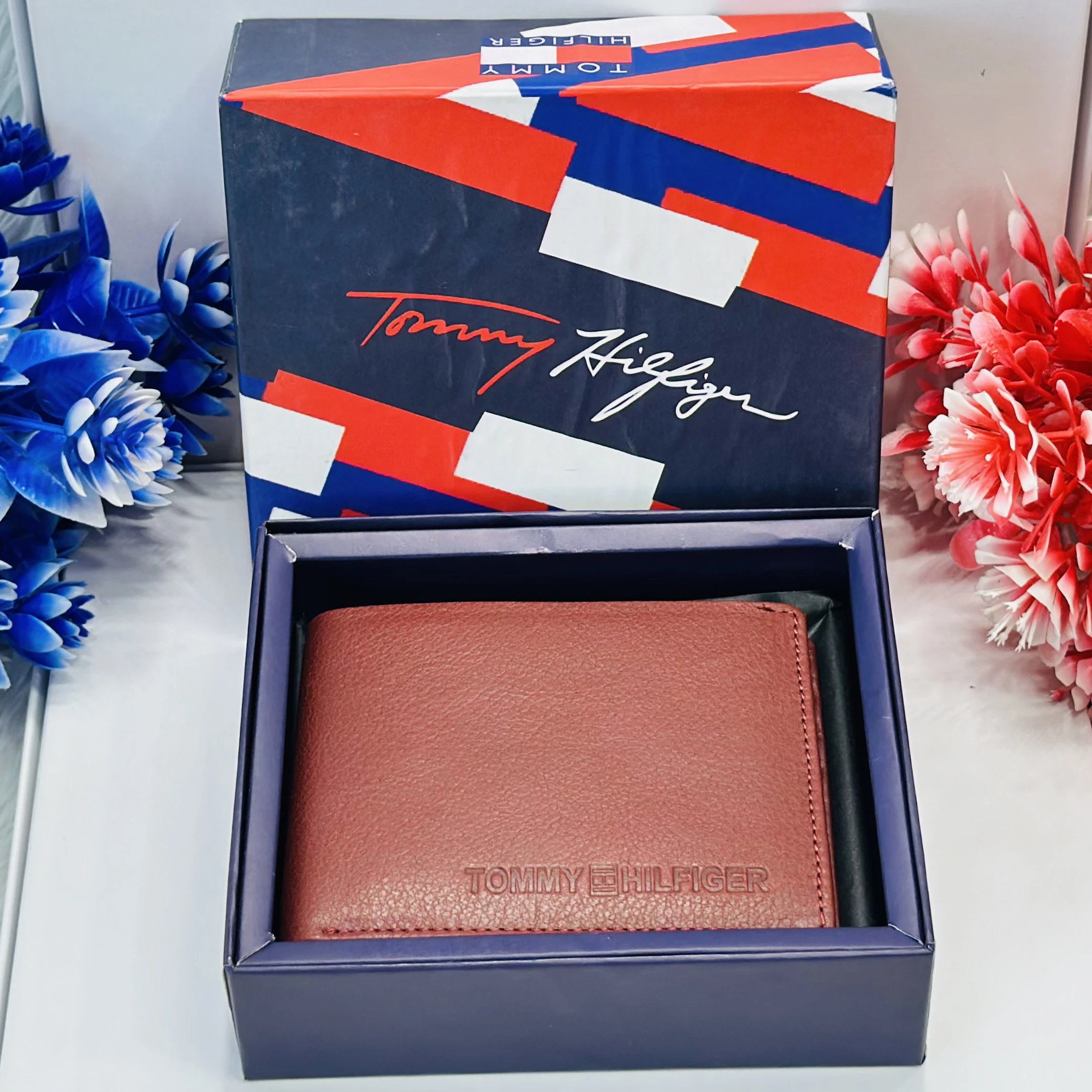 Tommy Hilfiger men's bi-fold leather wallet in a reddish-brown or wine color.