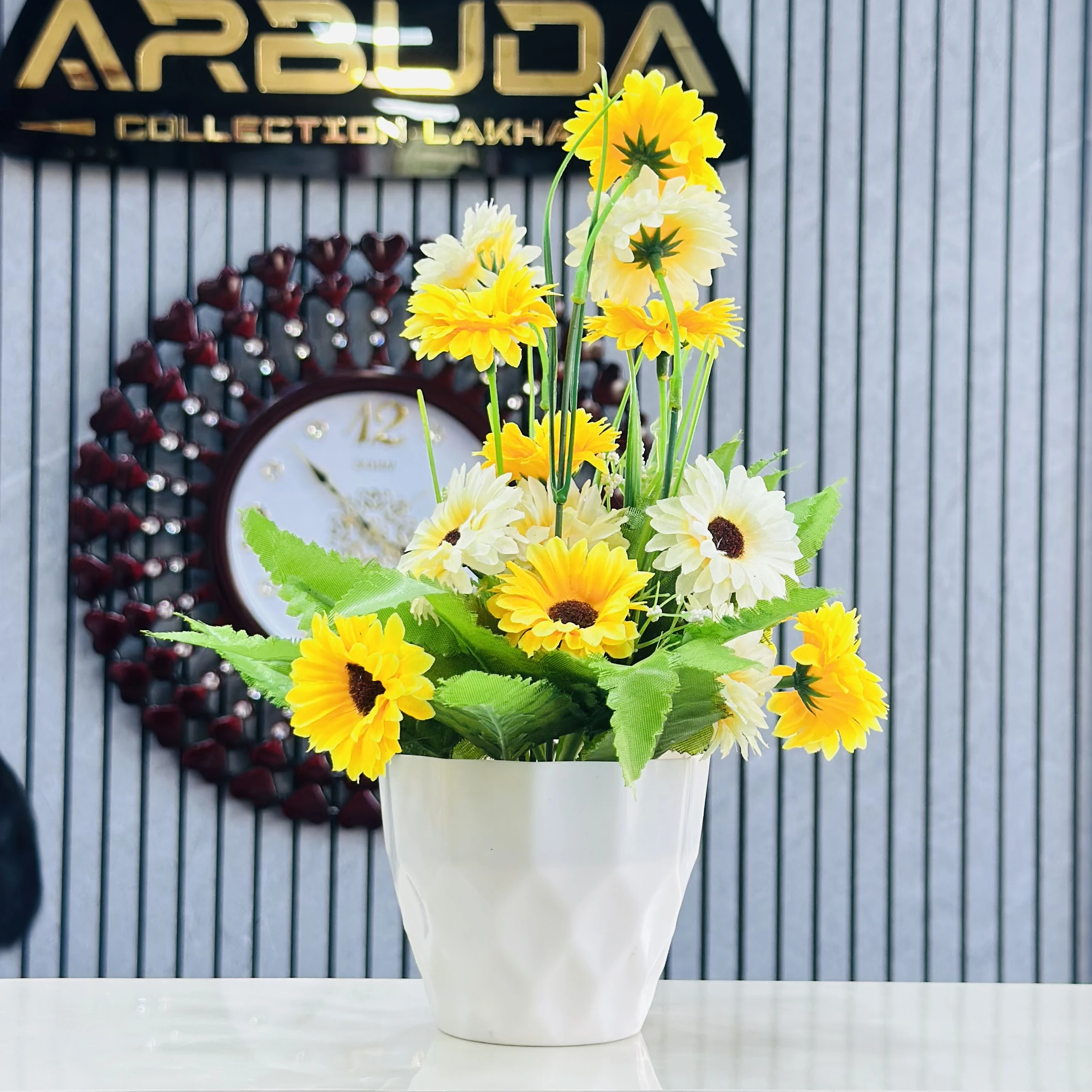 Sunflower arrangement in a white ceramic pot.