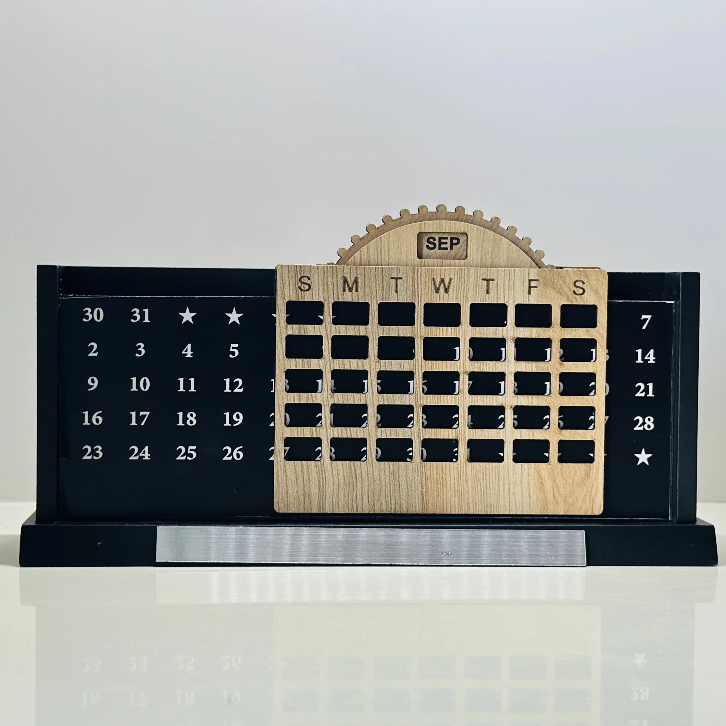 Wooden desk organizer that includes a perpetual calendar and a pen stand.