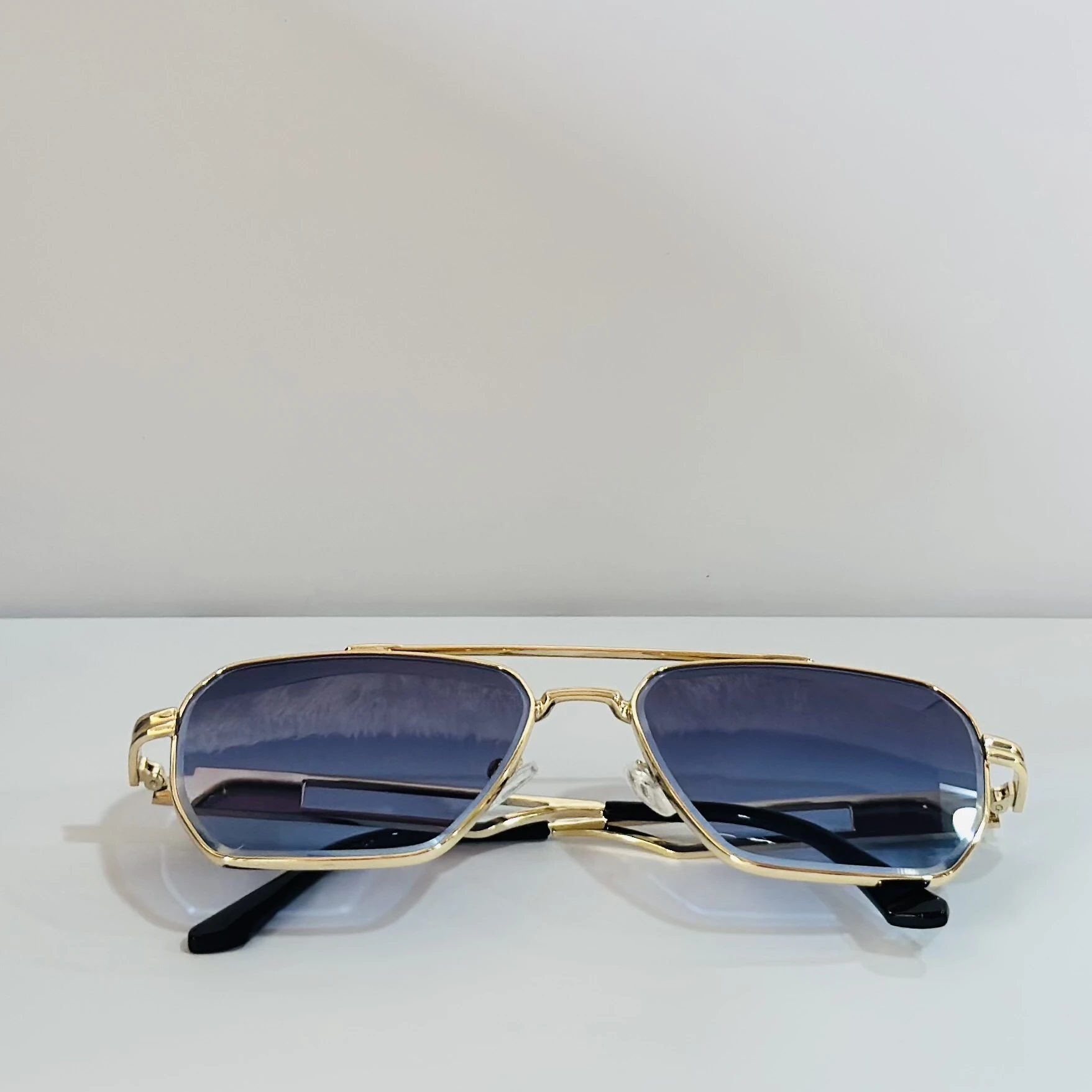 pair of gold-toned aviator sunglasses with gradient lenses.