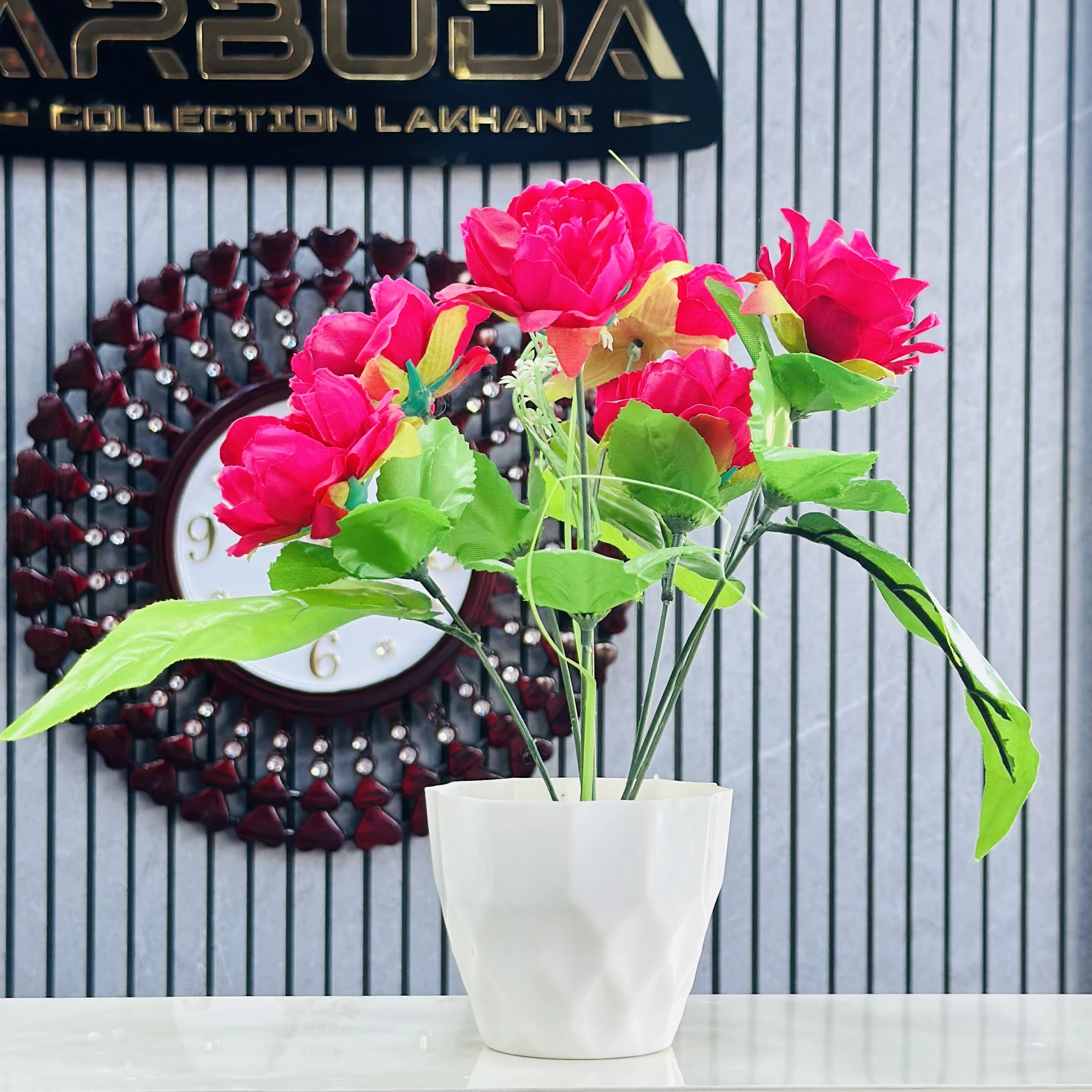 Red rose flower arrangement in a white pot.