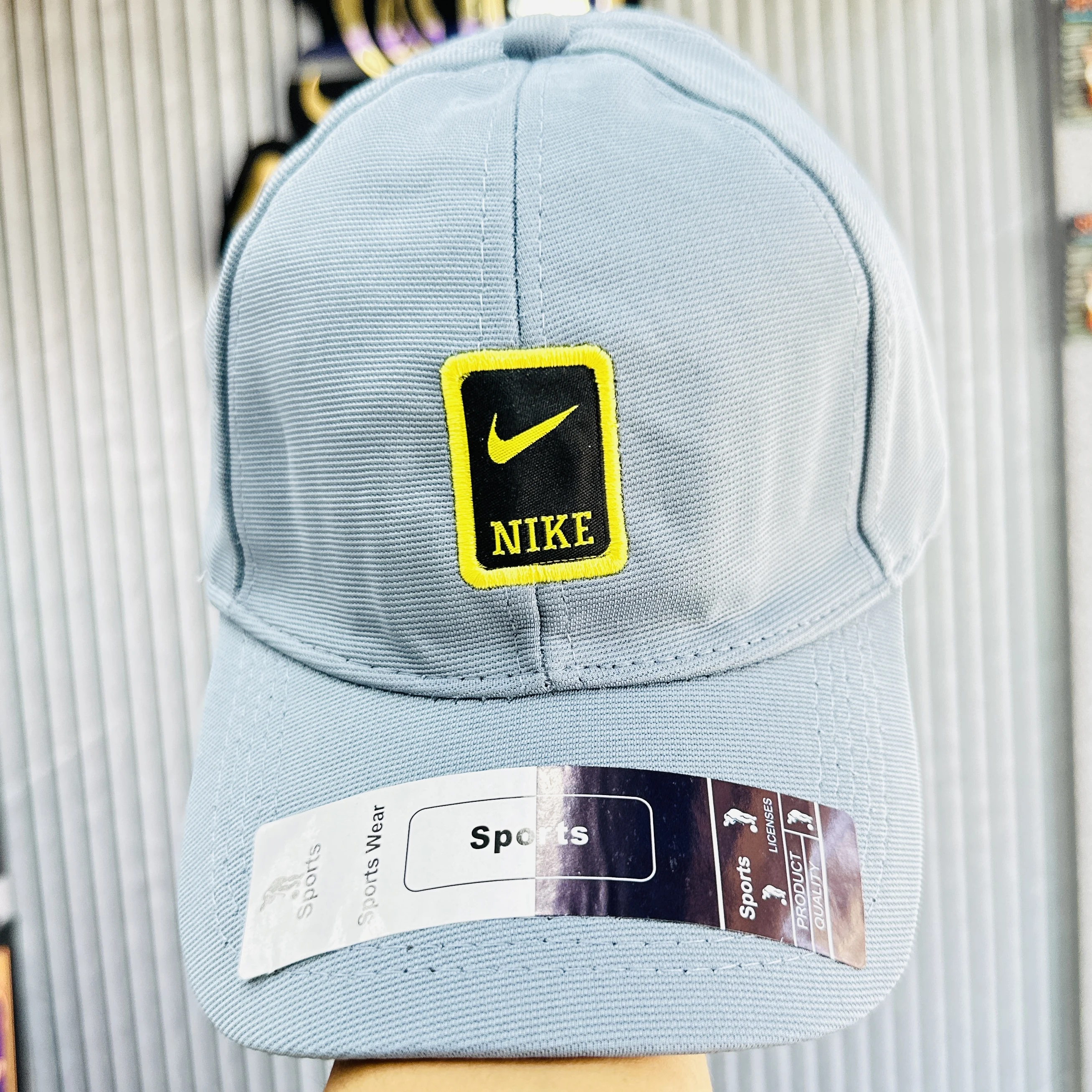 Blue Nike baseball cap featuring a yellow and black logo patch on the front.