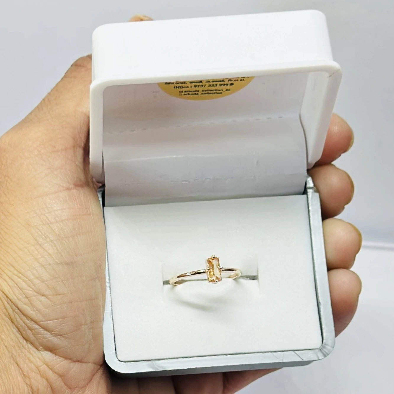An emerald-cut imperial topaz or citrine solitaire ring in 14k gold.