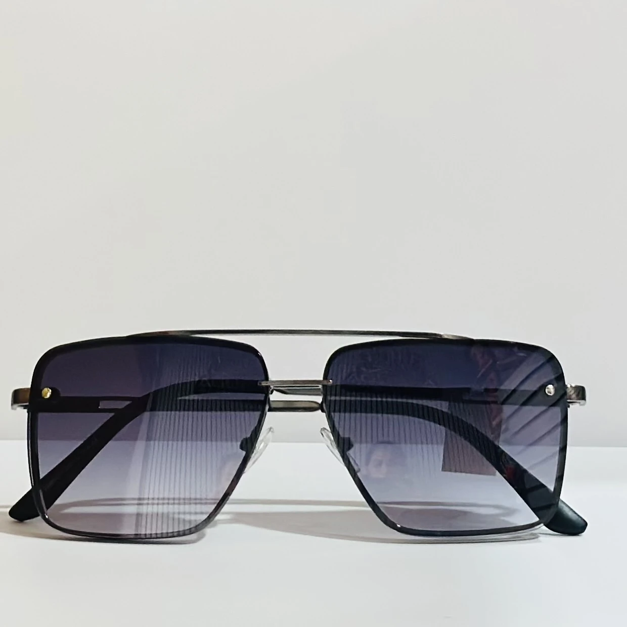 pair of square aviator sunglasses with a black metal frame and gradient lenses.