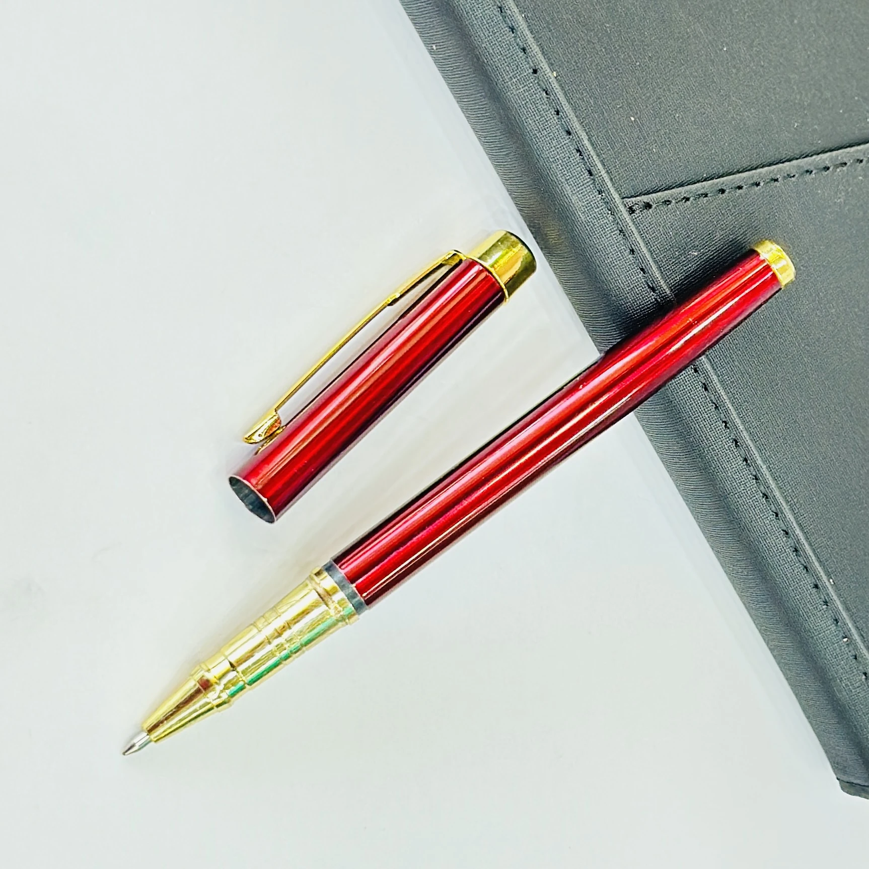 sleek maroon and gold metal rollerball pen