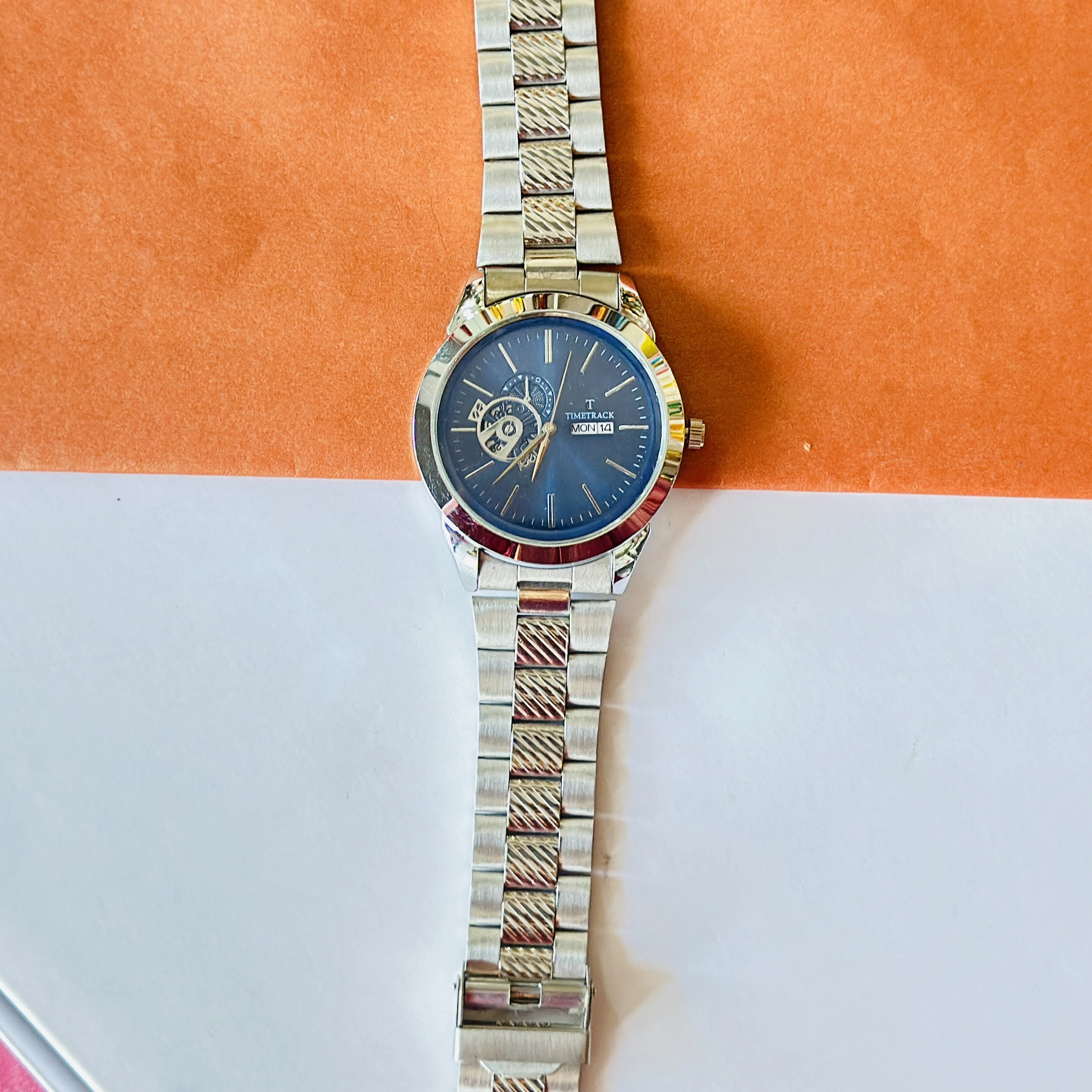 Timetrack stainless steel automatic watch with a blue dial and a bracelet strap.