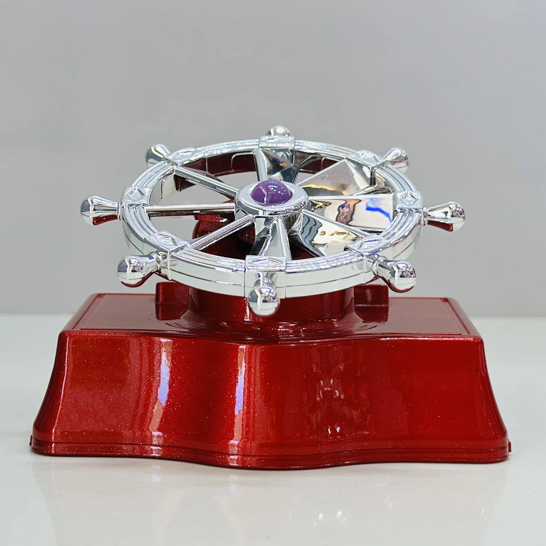 solar-powered car air freshener with a ship's helm wheel design.