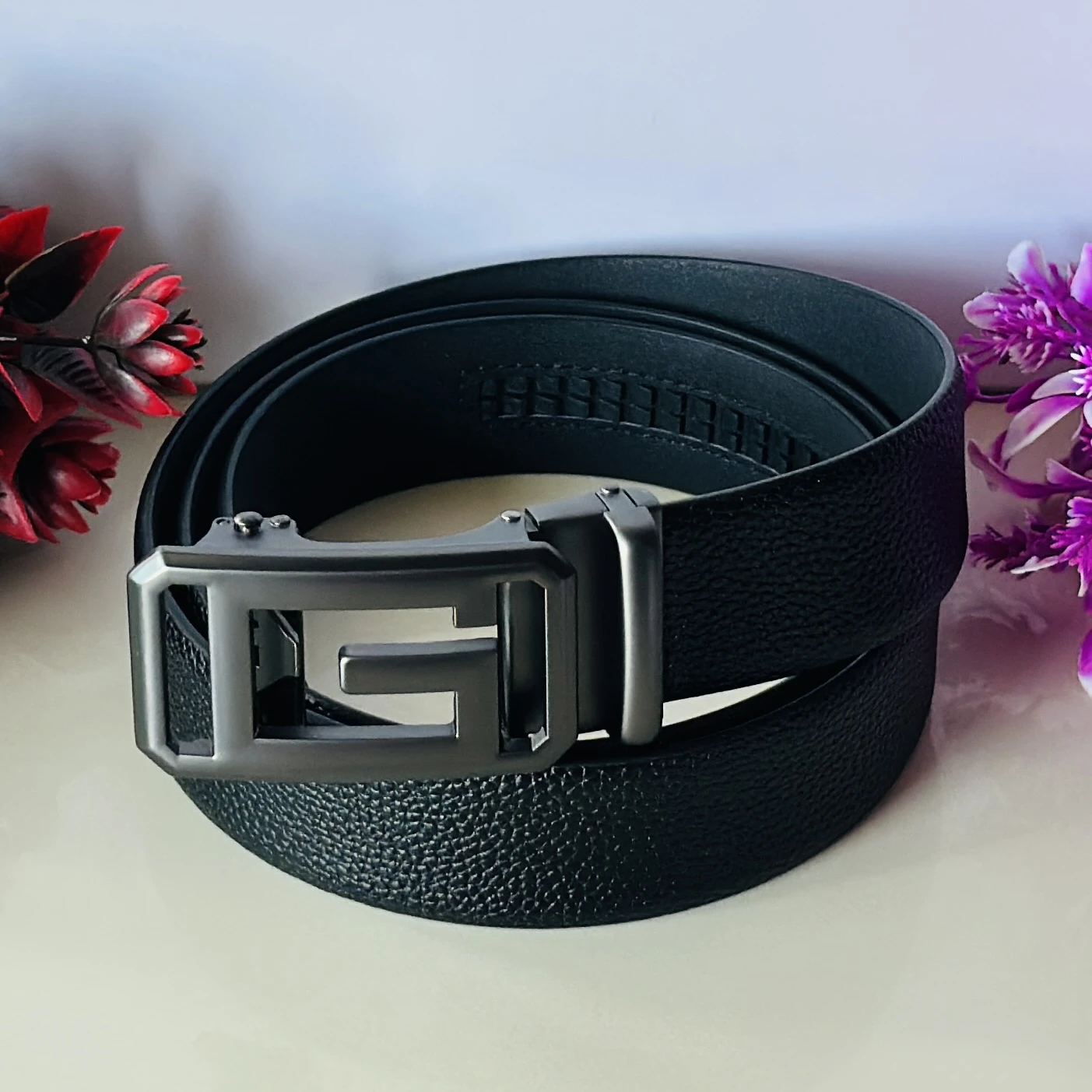 Men’s black faux leather automatic ratcheting belt with a 'G' shaped buckle.