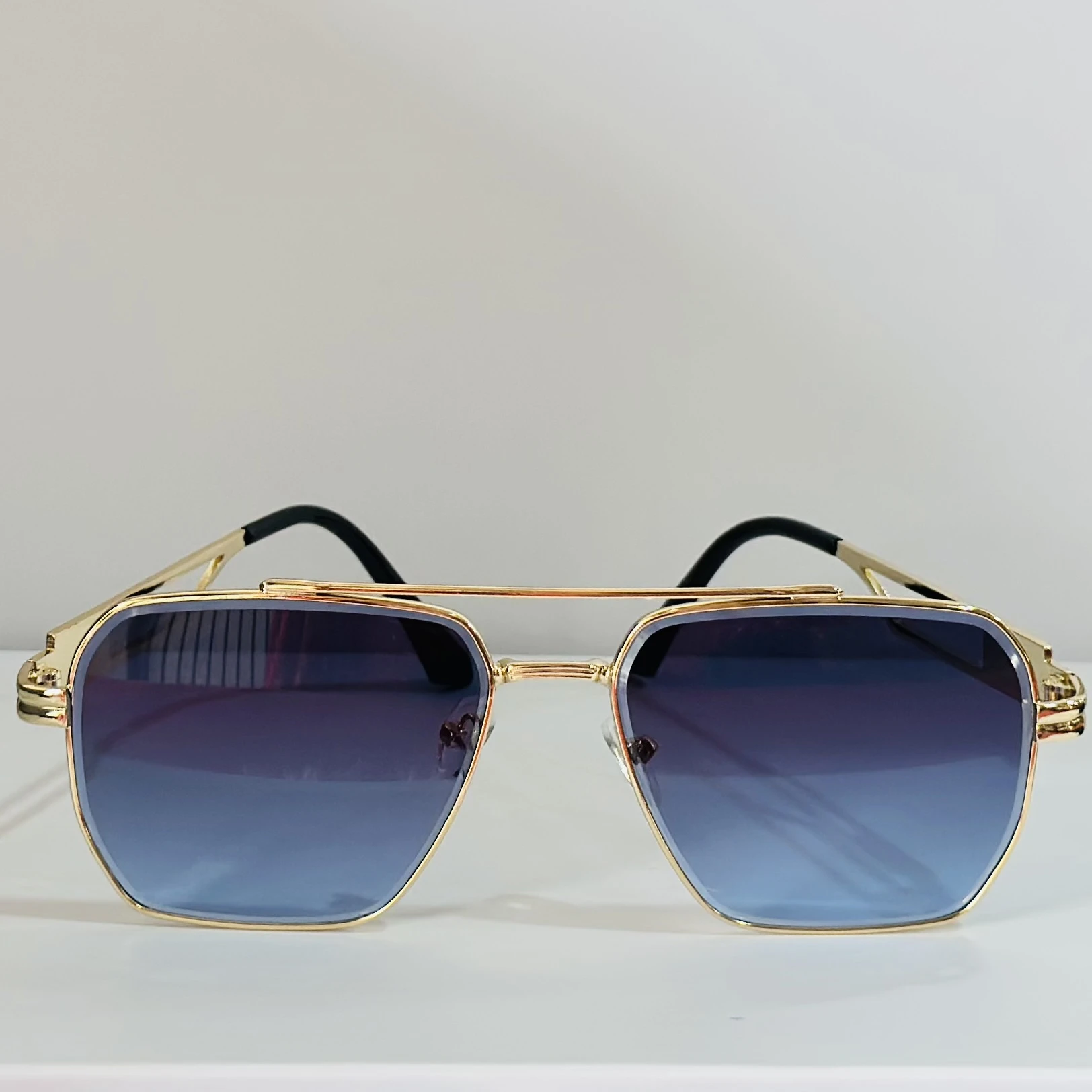 pair of gold-toned aviator sunglasses with gradient lenses.